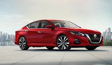 2023 Nissan Altima in red with city in background illustrating last year's 2022 model in Scott Clark Nissan in Charlotte NC